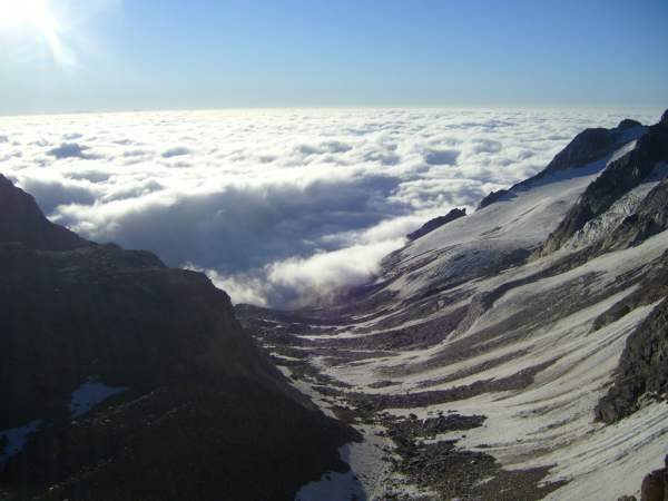 A gorgeous day in the Alps: at Zwischbergen pass 3268 m, above the clouds. Swiss Alps.