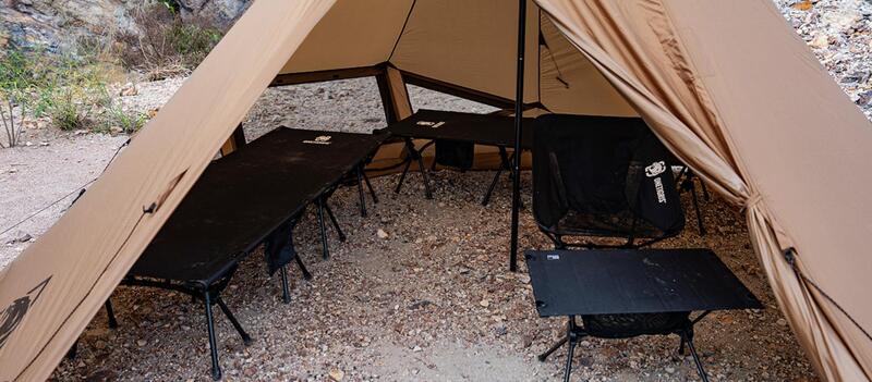 View with two cots, a camping chair, and a camping side table.