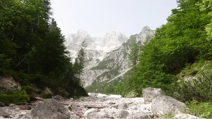 Walk along this dry water channel and turn right after the boulder.