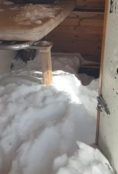 The door left open on a winter room.